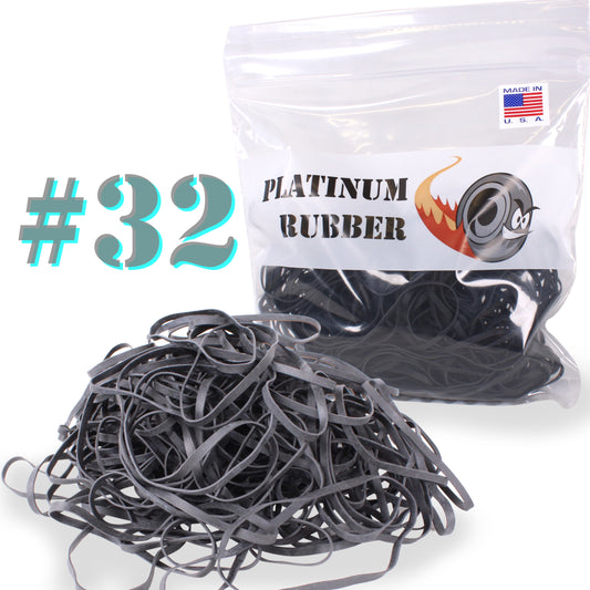 A clear plastic bag labeled with 'PLATINUM RUBBER #32' containing black rubber bands, with a bundle of rubber bands placed in front of the bag.